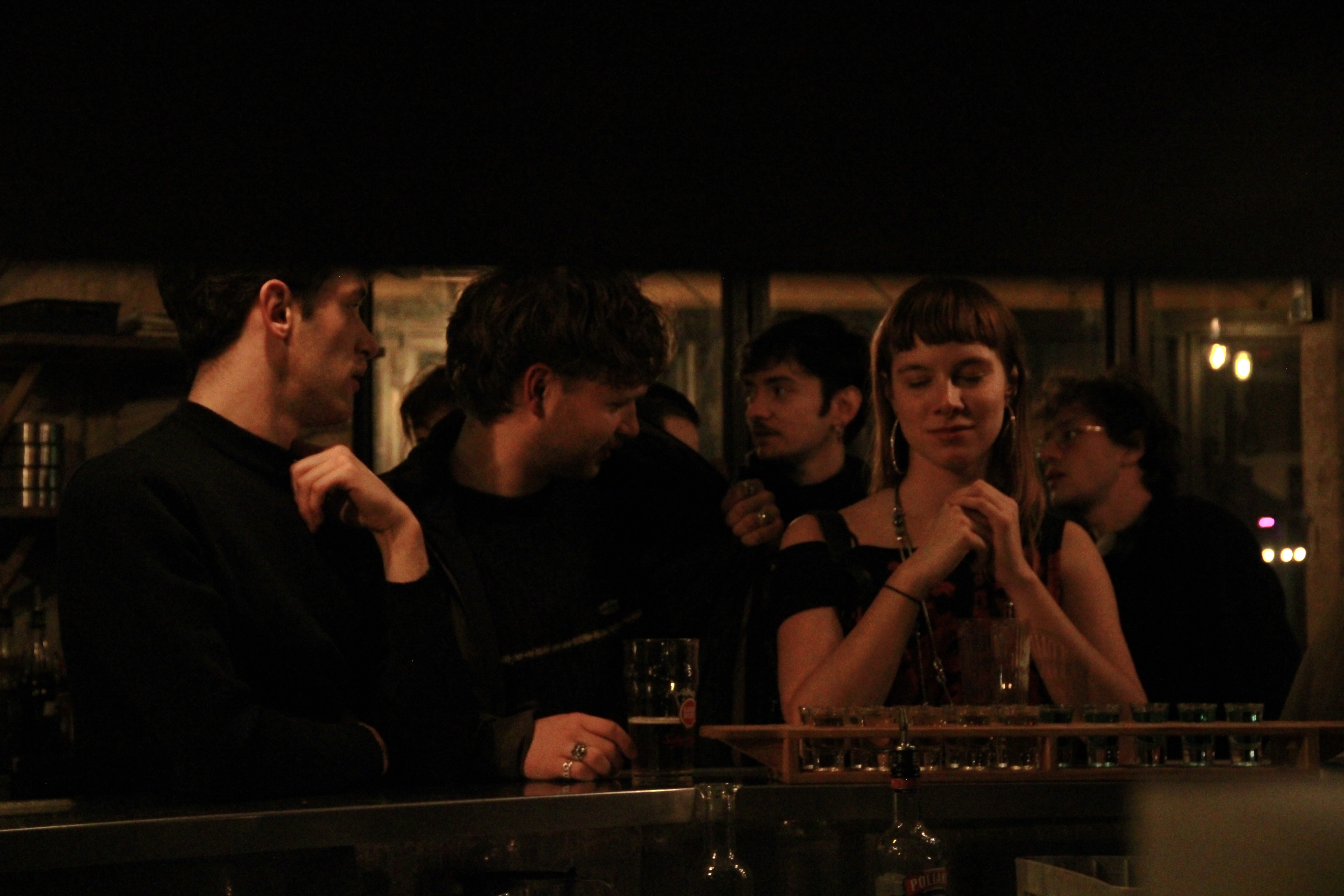 Photo prise lors de notre soirée d'inauguration de la réédition du premier numéro de la revue portant sur le thème Le Temps. Des personnes sont accoudées au comptoir d'un bar.